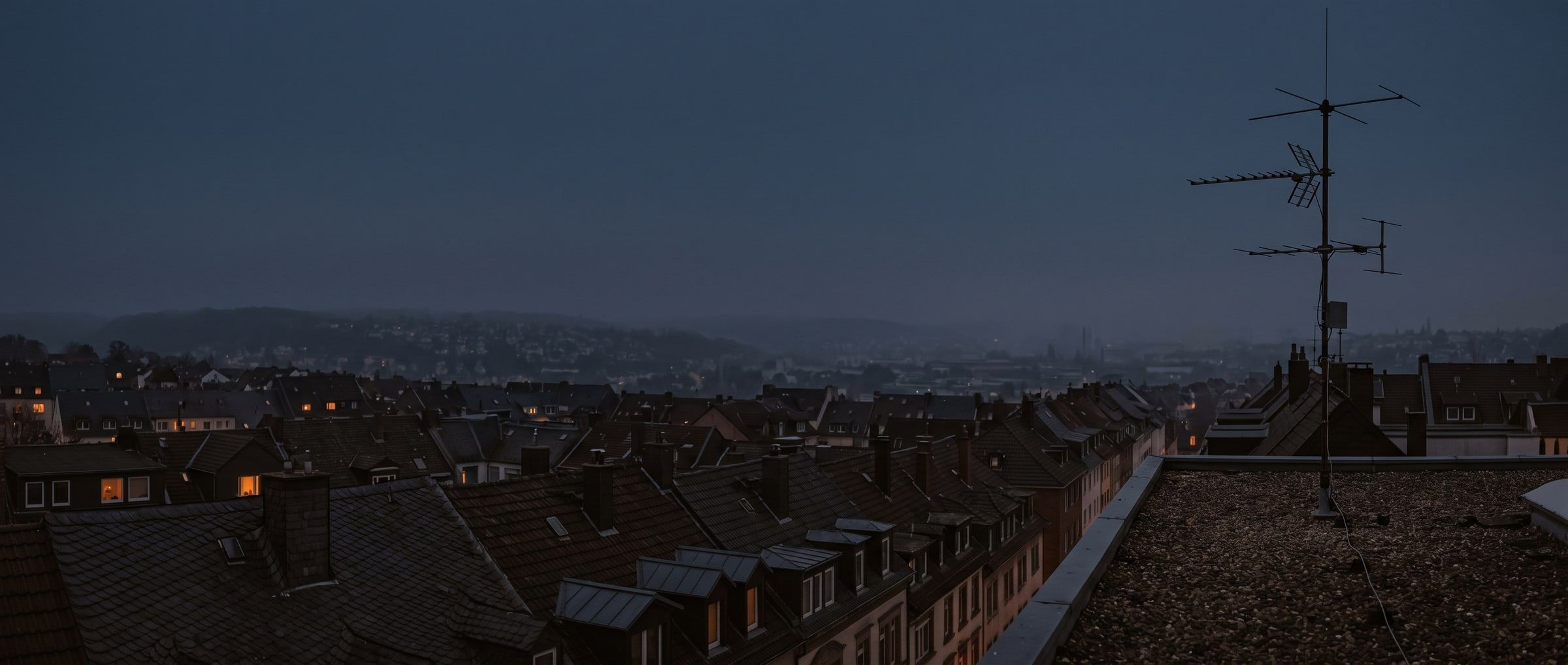 Blick über die Dächer einer Stadt, Antennenanlage auf einem Flachdach