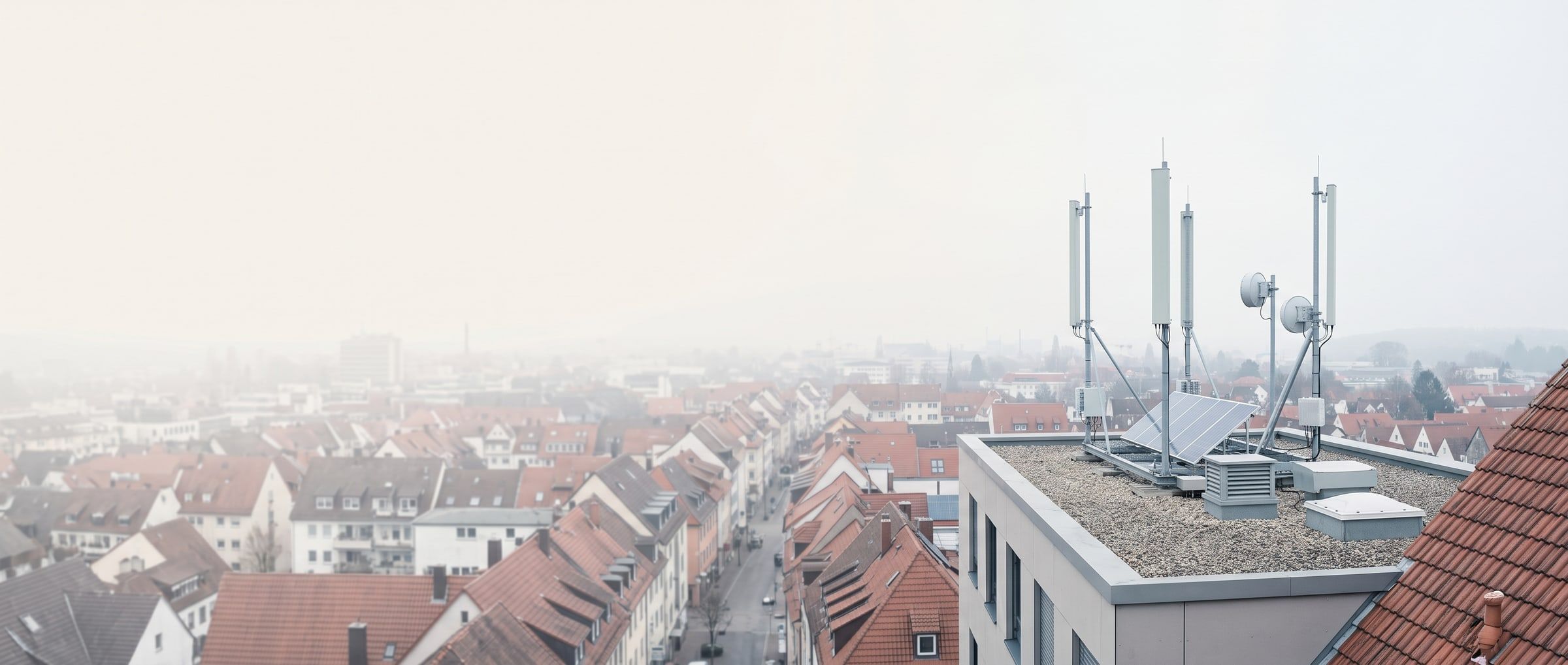 Blick über die Dächer einer Stadt, Antennenanlage auf einem Flachdach